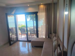 a living room with a couch and a view of the ocean at Mina's House Beachfront Apartments in Nikiti