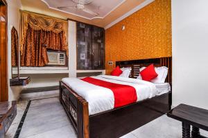 1 dormitorio con 1 cama grande con almohadas rojas en OYO Forever Banquet & Rooms en Nueva Delhi