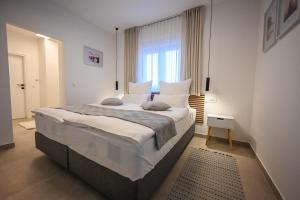 Un dormitorio con una cama grande y una ventana. en Villa Adria, en Privlaka 29 fotos más