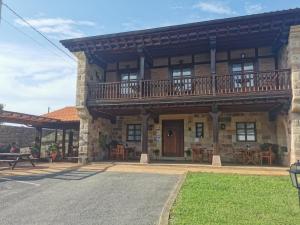 a large building with a balcony on top of it at Posada La Aldea in Oreña