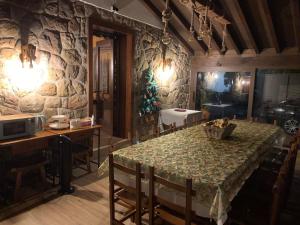 a dining room with a table and a stone wall at Posada La Aldea in Oreña