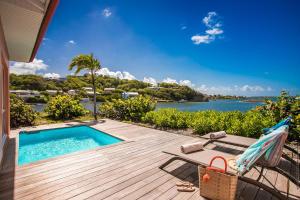 una terrazza con piscina, tavolo e sedia di Emeraude Villas - Bay a Le François
