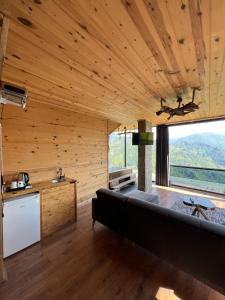 um quarto com um sofá e uma grande janela em Nirvana dağ evleri em Çamlıhemşin