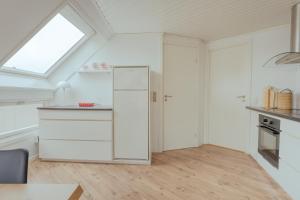 una cocina en el ático con armarios blancos y una ventana en Harbour View / 2BR / City Centre en Tórshavn