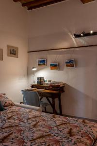 a bedroom with a desk and a table in a room at La sosta di Arrigo in Buonconvento