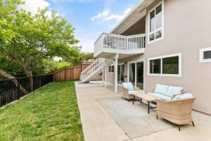 a home with a patio with chairs and a balcony at Marbella Lane - Charming & Serene home in Pacifica in Pacifica