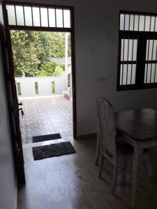 a dining room with a table and a door to a patio at Zentinal in Unawatuna