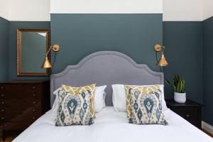 um quarto com uma cama branca e uma parede azul em Harriet - Quaint one bedroom apartment with easy parking em Kent