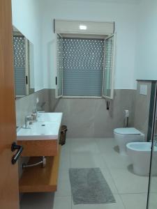 a bathroom with a sink and a toilet and a mirror at Villa Lory in Santa Maria Del Focallo