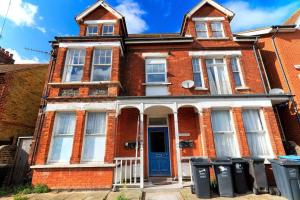 uma casa de tijolos vermelhos com uma porta azul em Harriet - Quaint one bedroom apartment with easy parking em Kent
