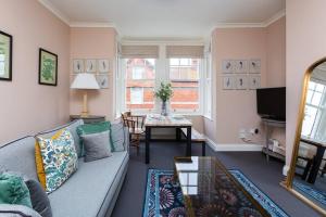 uma sala de estar com um sofá e uma mesa em Harriet - Quaint one bedroom apartment with easy parking em Kent