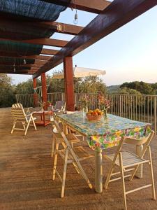 einen Tisch und Stühle auf einer Terrasse mit einem Sonnenschirm in der Unterkunft Villa Tramonto in Alghero