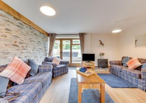 a living room with couches and a stone wall at Hafan Llewelyn in Builth Wells