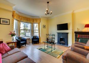 a living room with a couch and a fireplace at Chy An Porth in Padstow
