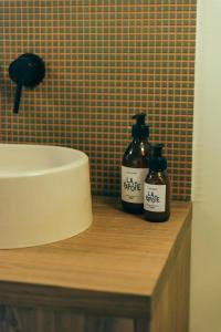 La salle de bains est pourvue de 2 bouteilles de savon et d'un lavabo. dans l'établissement La Papote, à Bourron-Marlotte