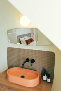 La salle de bains est pourvue d'un lavabo et d'un miroir. dans l'établissement La Papote, à Bourron-Marlotte