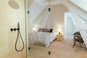 a bedroom with a bed and a glass shower door at La Papote in Bourron-Marlotte