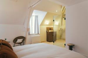 a bedroom with a white bed and a mirror at La Papote in Bourron-Marlotte