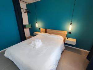een slaapkamer met een wit bed en 2 handdoeken bij Marconi Apartment in Chieri