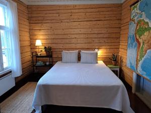 a bedroom with a white bed in a wooden wall at Kolin Mattila B&B in Kolinkylä +37 photos