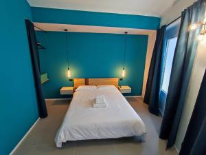 een slaapkamer met een groot bed met een blauwe muur bij Marconi Apartment in Chieri