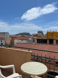 Una mesa y sillas en un balcón con vista a una ciudad. en Apartmani Goran i Jelena Zec, en Budva