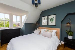 1 Schlafzimmer mit einem großen weißen Bett und 2 Fenstern in der Unterkunft Queenie - Charming one bedroom apartment in quiet location in Kent