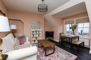 ein Wohnzimmer mit einem weißen Sofa und einem Tisch in der Unterkunft Queenie - Charming one bedroom apartment in quiet location in Kent