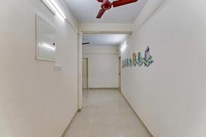 um corredor com uma ventoinha de tecto e uma parede branca em OYO Flagship 15148 Sky Pix Near Kasi Talkies em Chennai
