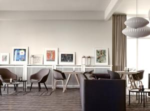 克厄的住宿－克姆威爾克厄海濱酒店，客厅配有椅子、桌子和椅子