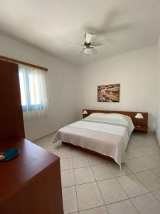 a bedroom with a bed and a ceiling fan at Milithos Apartments 1 in Adamantas