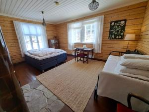 a bedroom with a bed and a table and two windows at Kolin Keidas in Kolinkyl&auml;