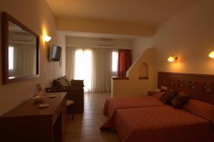 a hotel room with two beds and a couch at Summer Time - Tinos Apartments in Agios Sostis