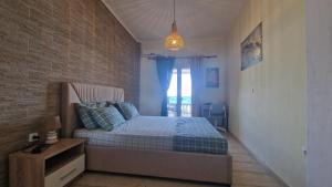 una camera con letto e muro di mattoni di Nereida (Νηρηίδα) Luxury Apartment a Kokkari