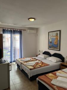 Una habitación de hotel con dos camas y una ventana. en Apartmani Goran i Jelena Zec, en Budva
