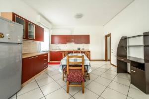 een keuken met een tafel en een keuken met rode kasten bij [Parking&Wifi free / Hesperia] Groundfloor Oasis in Modena