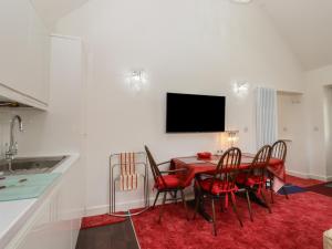 uma sala de jantar com uma mesa vermelha e cadeiras em Barons Mews em Herne Bay