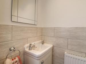 a white bathroom with a sink and a mirror at Barons Mews in Herne Bay +18 photos