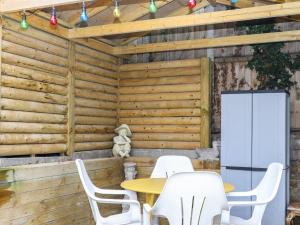 a patio with white chairs and a table and a refrigerator at Barons Mews in Herne Bay