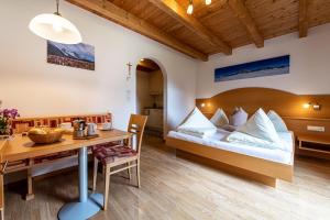 アンテルセルヴァ・ディ・メッツォにあるApartments Nature Apis Landheimのベッドとテーブルが備わるホテルルームです。
