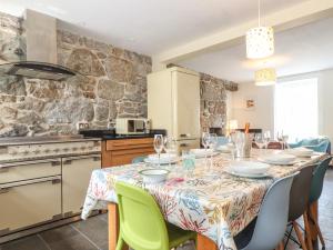 a kitchen with a table with chairs and a table cloth at Mermaid Cottage in Penzance