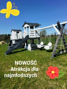 un parque infantil con 2 sillas y un columpio en Sunset- Dom zachód słońca Spa, en Mołdzie