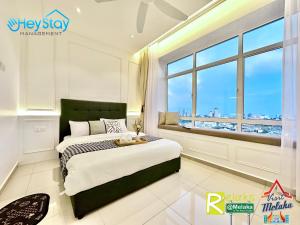 a bedroom with a bed and a large window at Novo 8 Residence Bachang By Heystay Management in Kampong Tambak