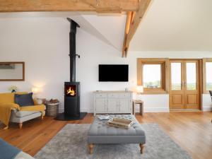 uma sala de estar com lareira e sofá em Trevilges Cottage em Helston