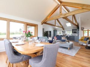uma sala de jantar e sala de estar com uma mesa de madeira e cadeiras em Trevilges Cottage em Helston
