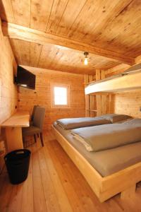 Un dormitorio con 2 camas y un escritorio en una habitación. en Ferienhof Holzmeister, en Sankt Jakob in Haus