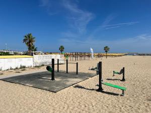 a playground on a sandy beach with palm trees at "Casa incantevole" fronte mare Pescara in Pescara