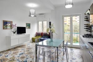 索倫托的住宿－Caruso 2 - Sorrento，厨房以及带玻璃桌的起居室。