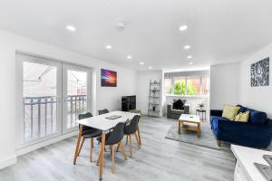 a living room with a table and a blue couch at Woodstock House - A Spacious Apartment Block with 9 Two-Bedroom Flats in Hucknall