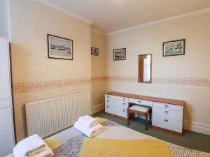 a bedroom with two beds and a dresser and a mirror at Sunnyside Holiday Apartment 1 in Bridlington